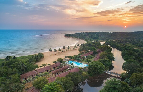 A resort with a swimming pool, beach, and river.