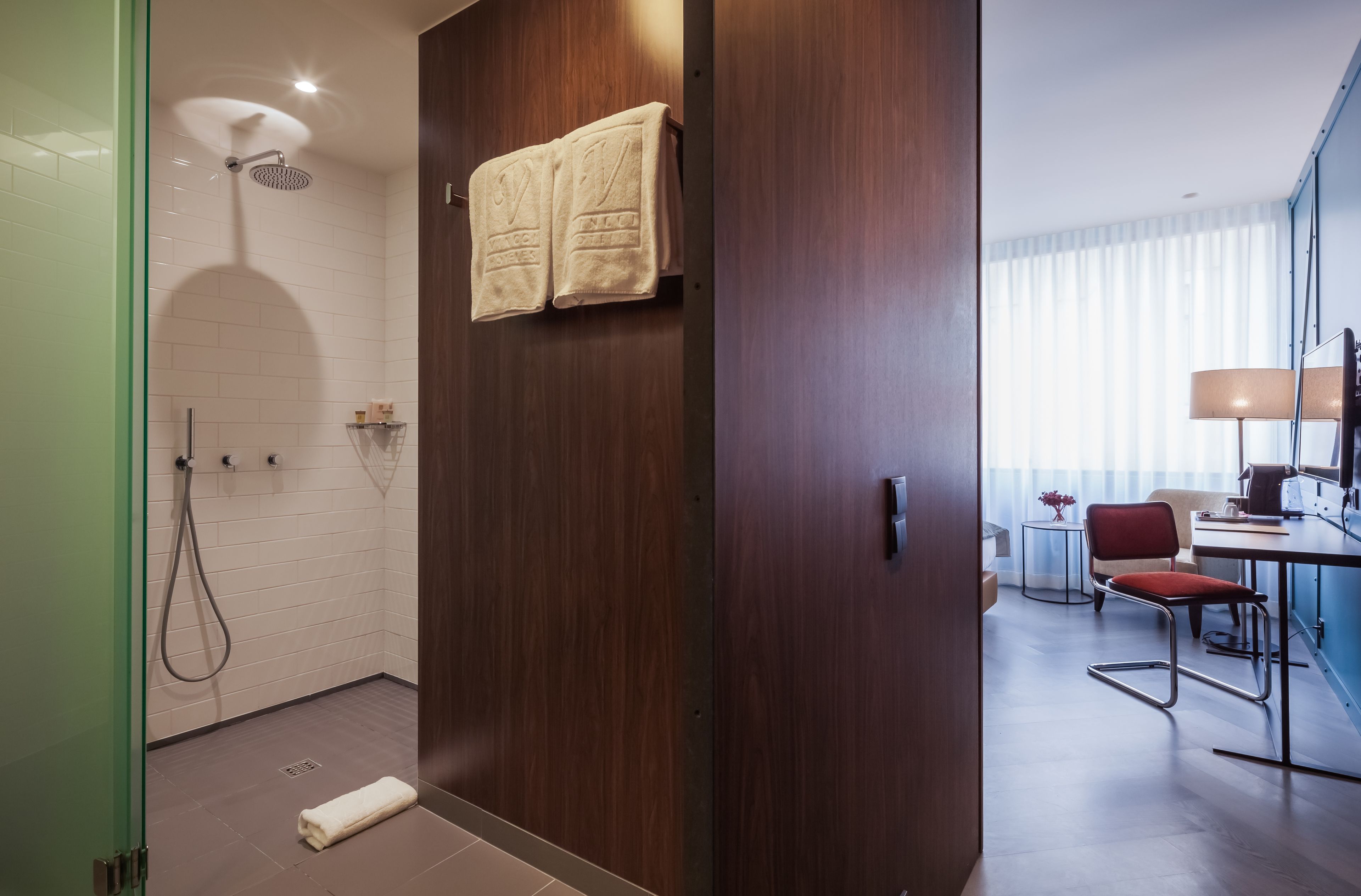Un baño moderno con ducha, perchero y un inodoro a la vista.