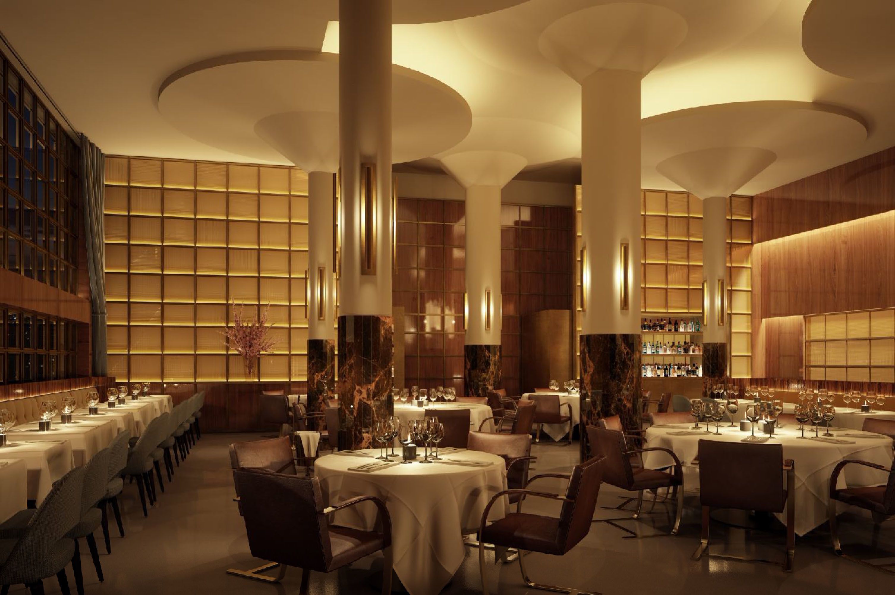 A spacious dining area with multiple round tables, each set with fine china and glassware. The room features high ceilings with circular designs and large windows allowing natural light.