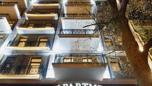 A building with a sign reading "Apartments City Hotel" and a glass entrance.