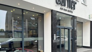 El exterior del Hotel Garner Anling con amplias ventanas de vidrio, una fachada moderna y una entrada visible.