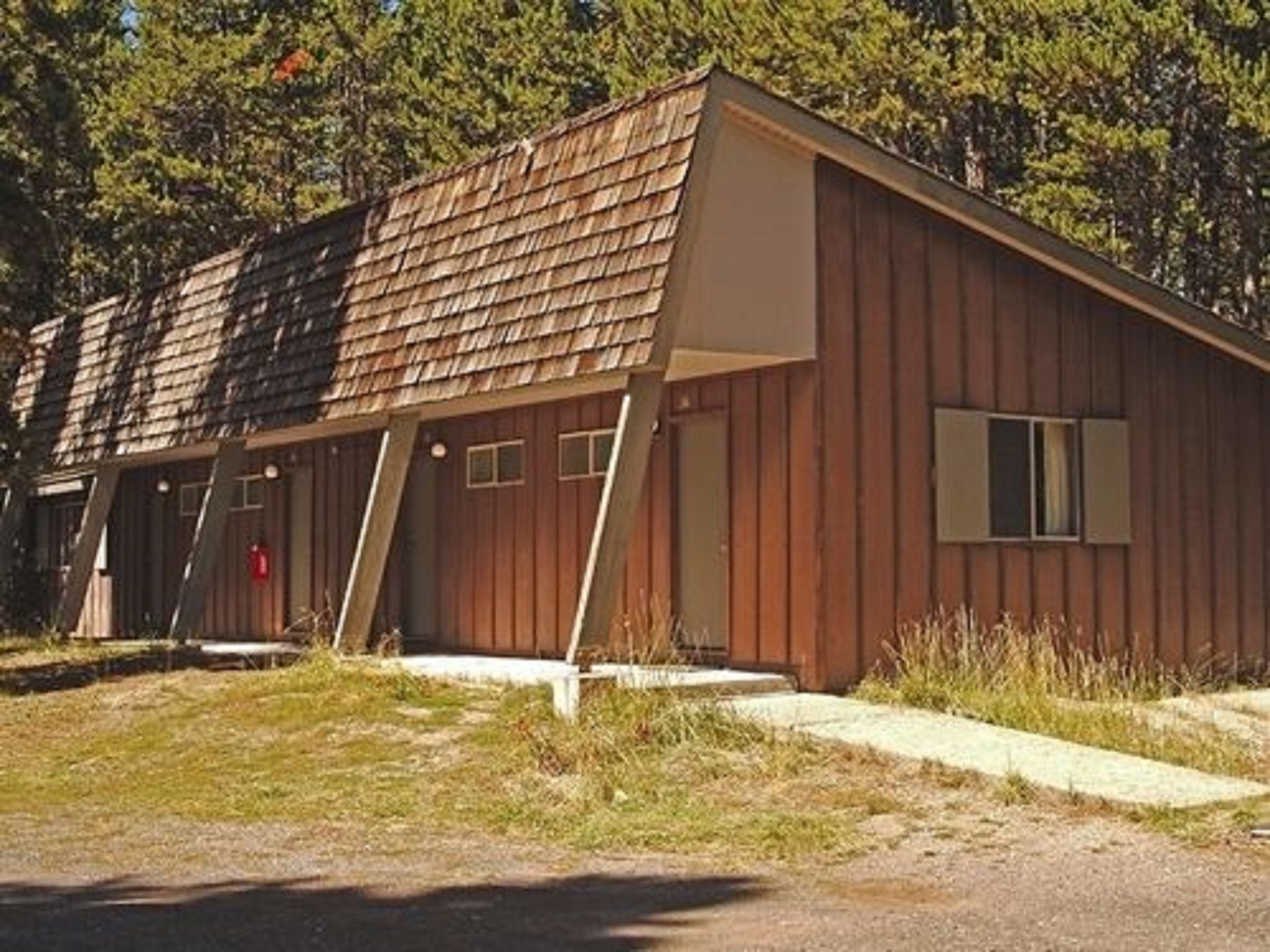 Un bâtiment en bois d’un seul étage, doté d’un toit en pente, d’un petit porche et d’une seule porte.
