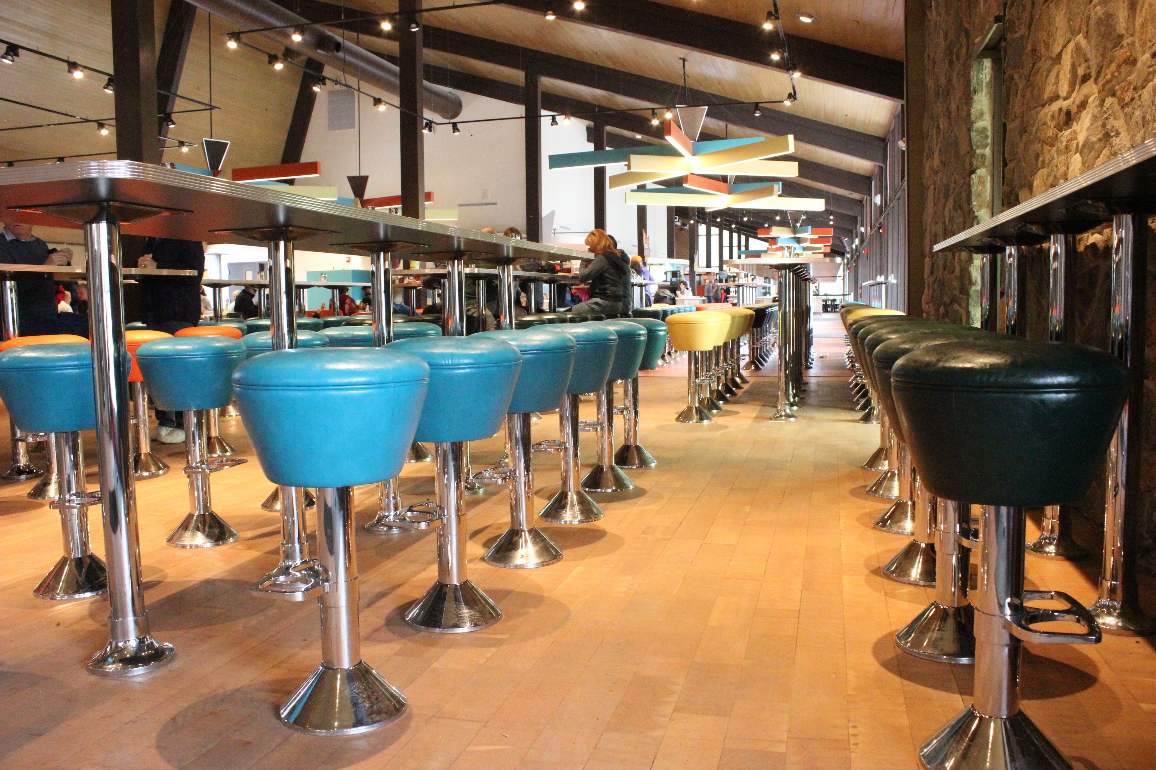 A restaurant interior with multiple bar stools and tables.