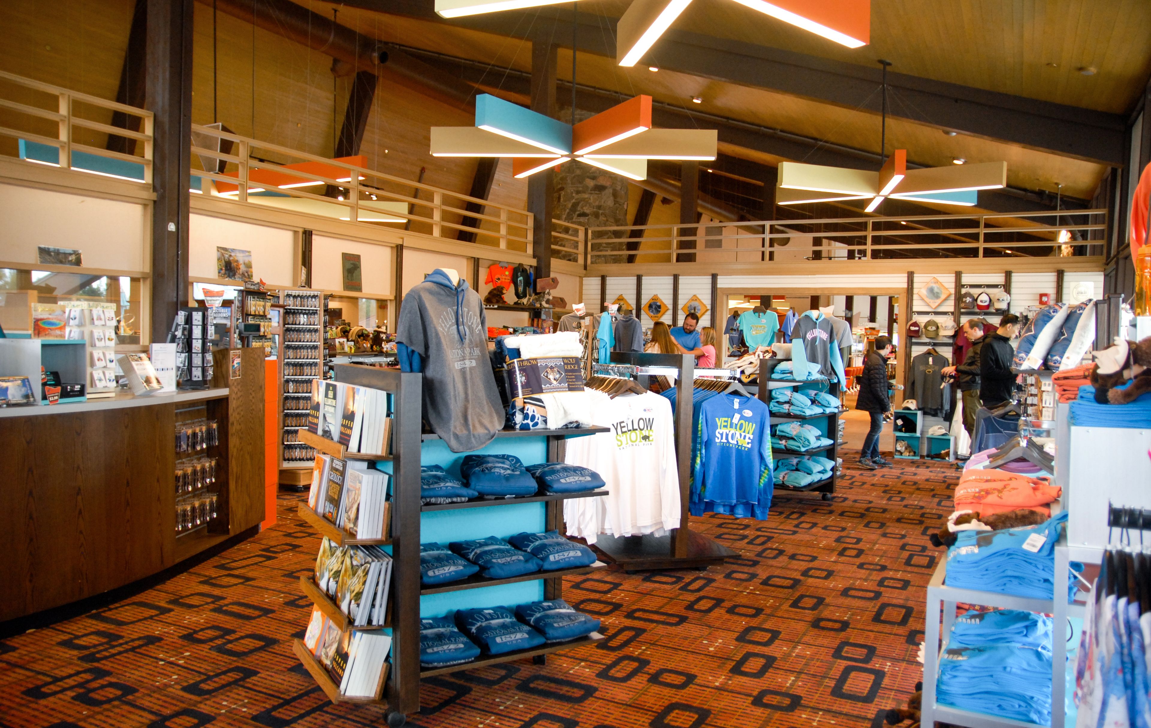 Een ruime winkel met hoge plafonds en moderne verlichting. De rekken zijn gevuld met diverse producten, en er zijn verschillende mensen aan het rondkijken.
