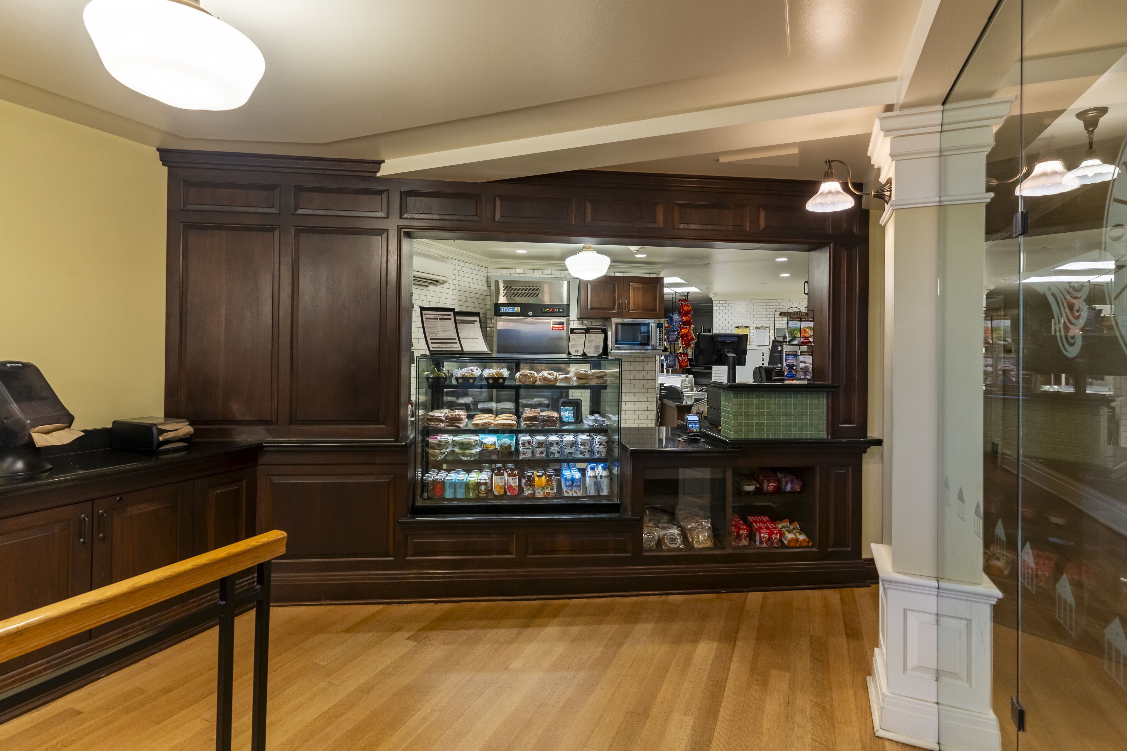 A bakery with a display case of baked goods and a counter with a cash register.
