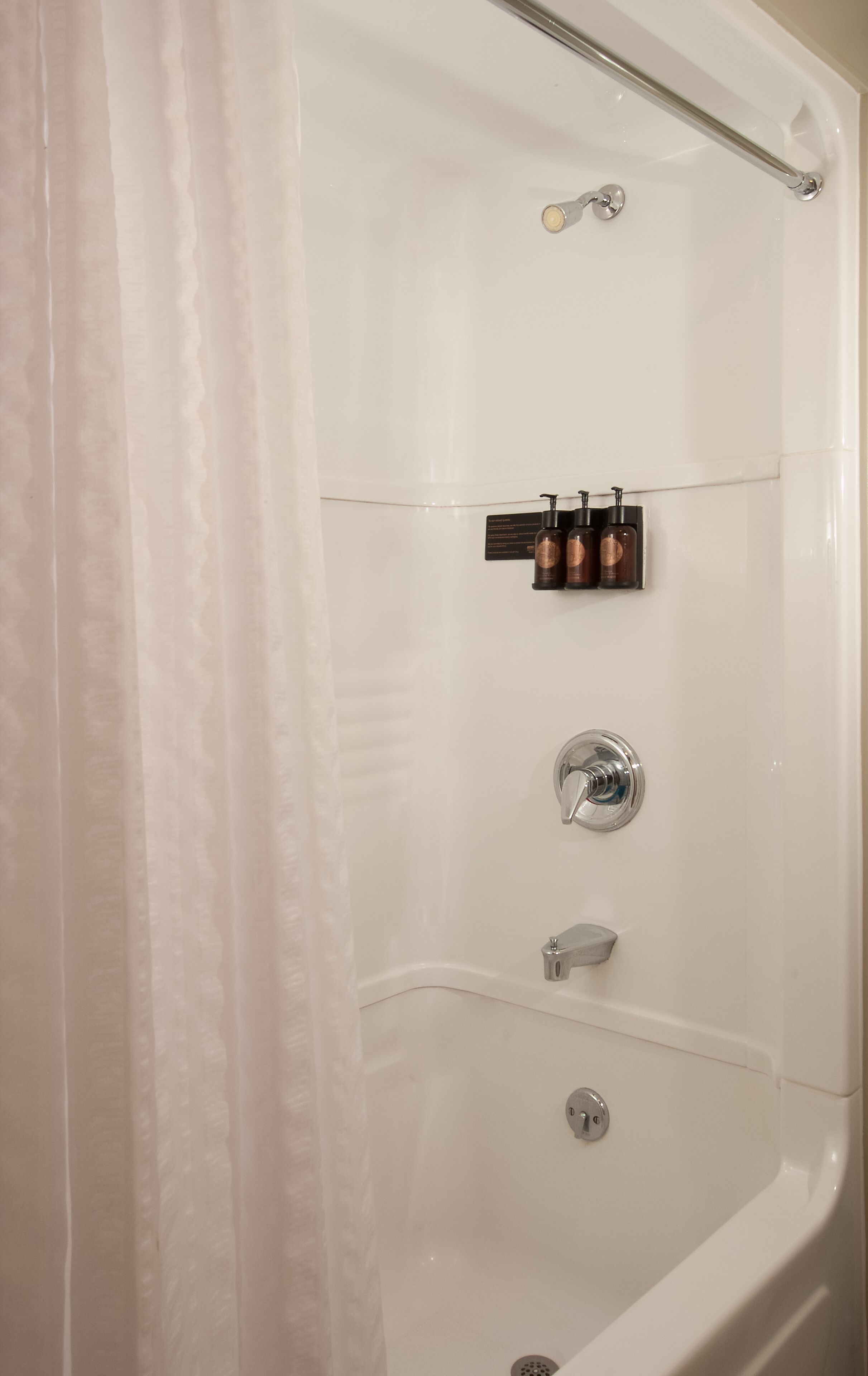A modern bathroom with a bathtub, a shower, and a toilet.