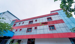 A modern building with a red and grey facade, featuring the 'treebo' logo and 'trend' text.