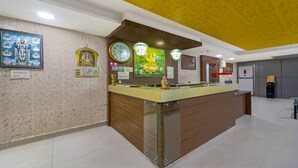 Un espace d’accueil doté d’un comptoir en bois, de horloges murales et d’œuvres d’art à caractère religieux.