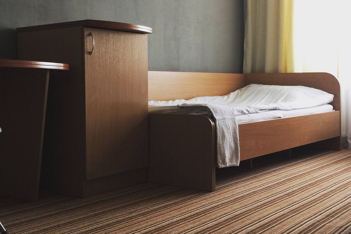 Ein Hotelzimmer mit einem Bett, einem Holztisch und einem Bild an der Wand.