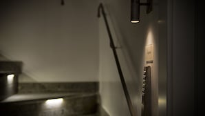 Una escalera con barandilla y panel de control de ascensor instalado en la pared.