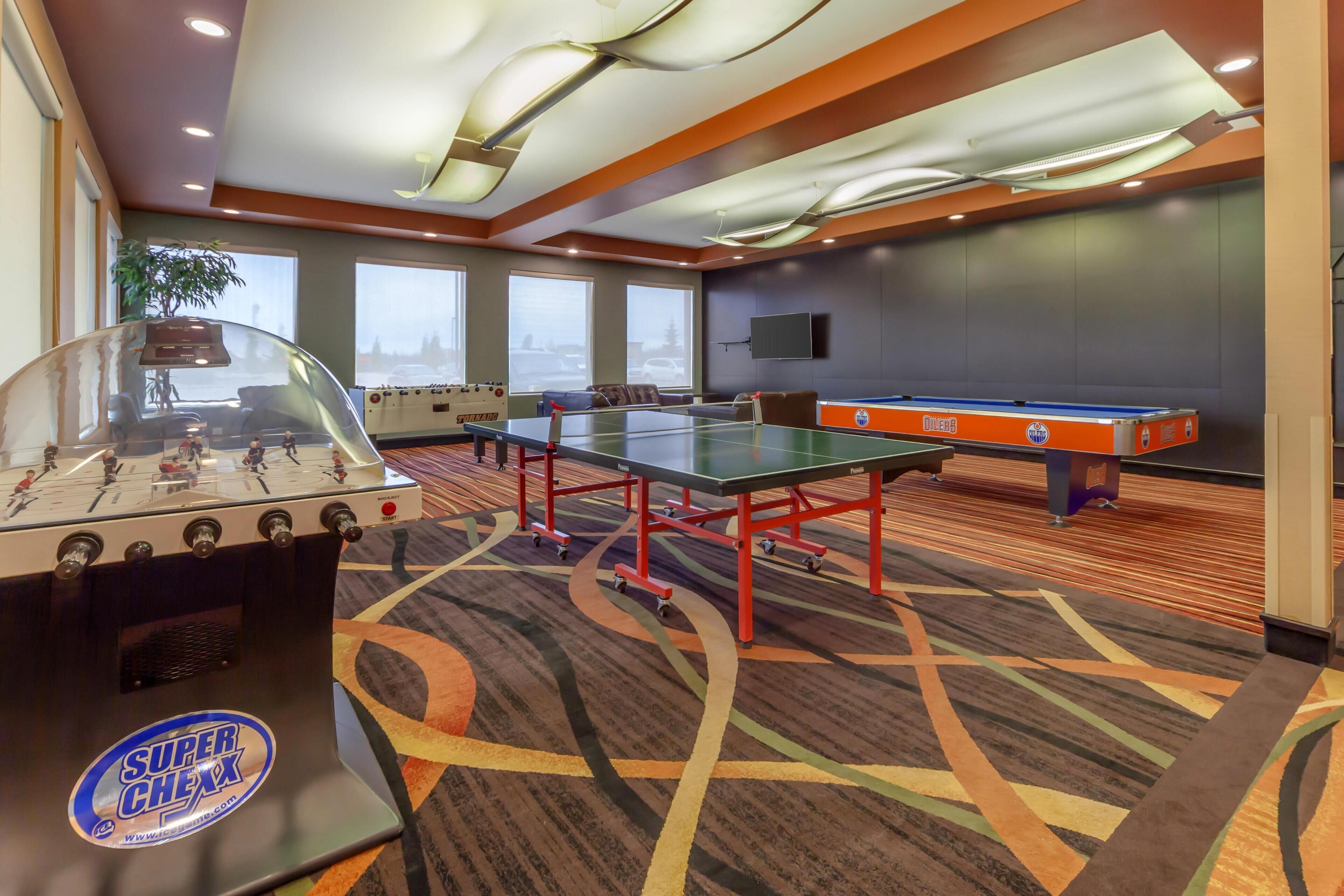 Una habitación con mesa de fútbol de mesa, mesa de billar y el logo de Super Chex.