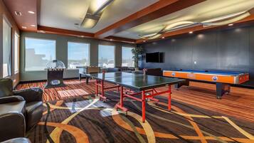Relax in a spacious lounge area with a pool table, comfortable seating, and a flat-screen TV.