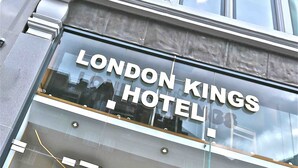 The London Kings Hotel facade with large windows and a clear sky. - London Kings Hotel (London)