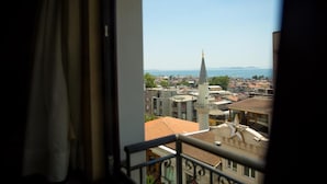 Blick vom Balkon auf eine Stadtlandschaft mit Gebäuden und einem Kirchturm.