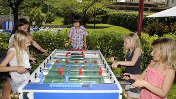 Children enjoy a game of foosball in the resort's lush outdoor space.
