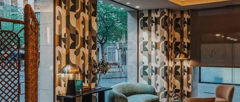 Un salón moderno con sofá, sillones, una mesa de centro y una alfombra decorativa.