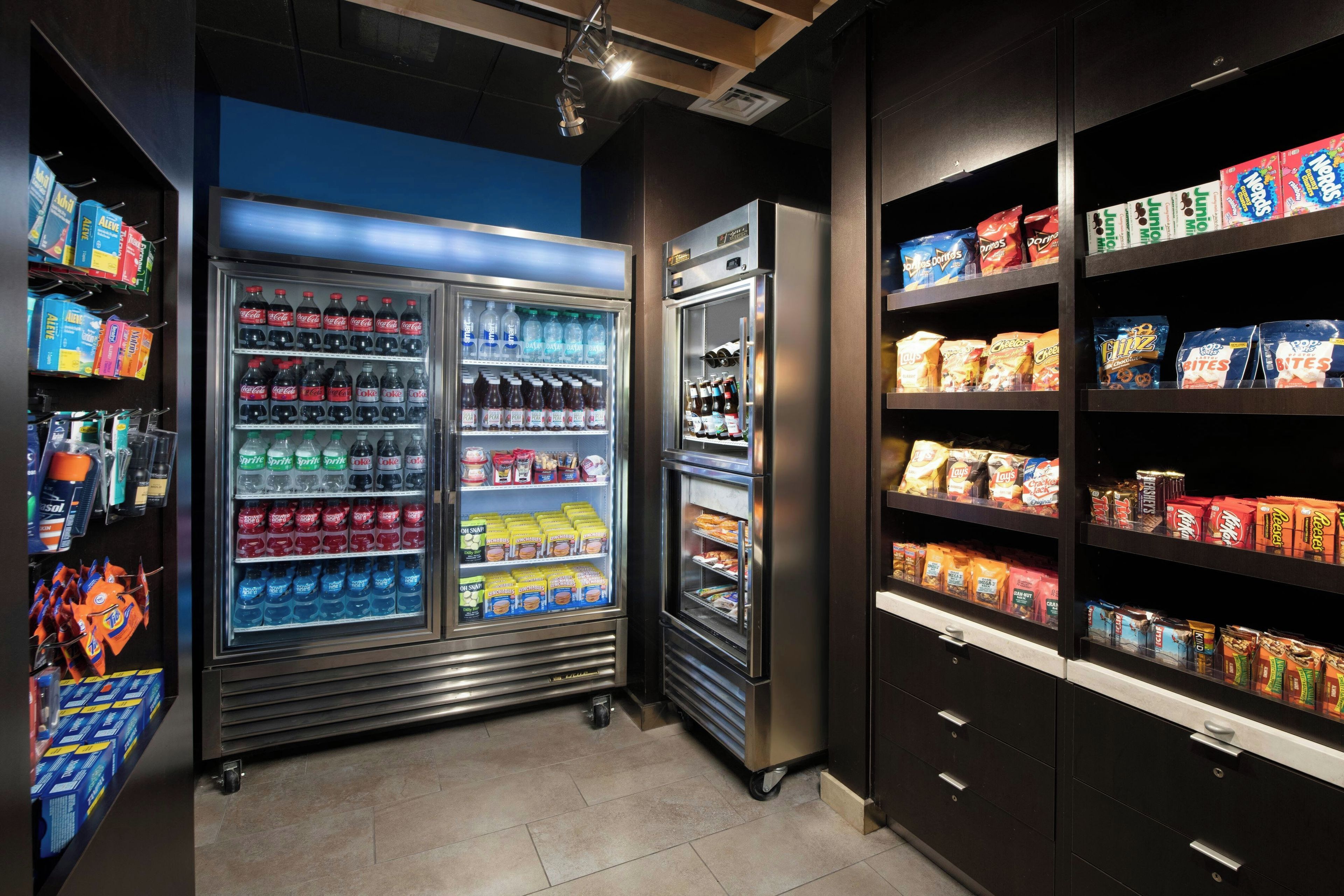 Un área de venta con diversas opciones de bocadillos y bebidas, como refrescos, papas fritas y agua embotellada.