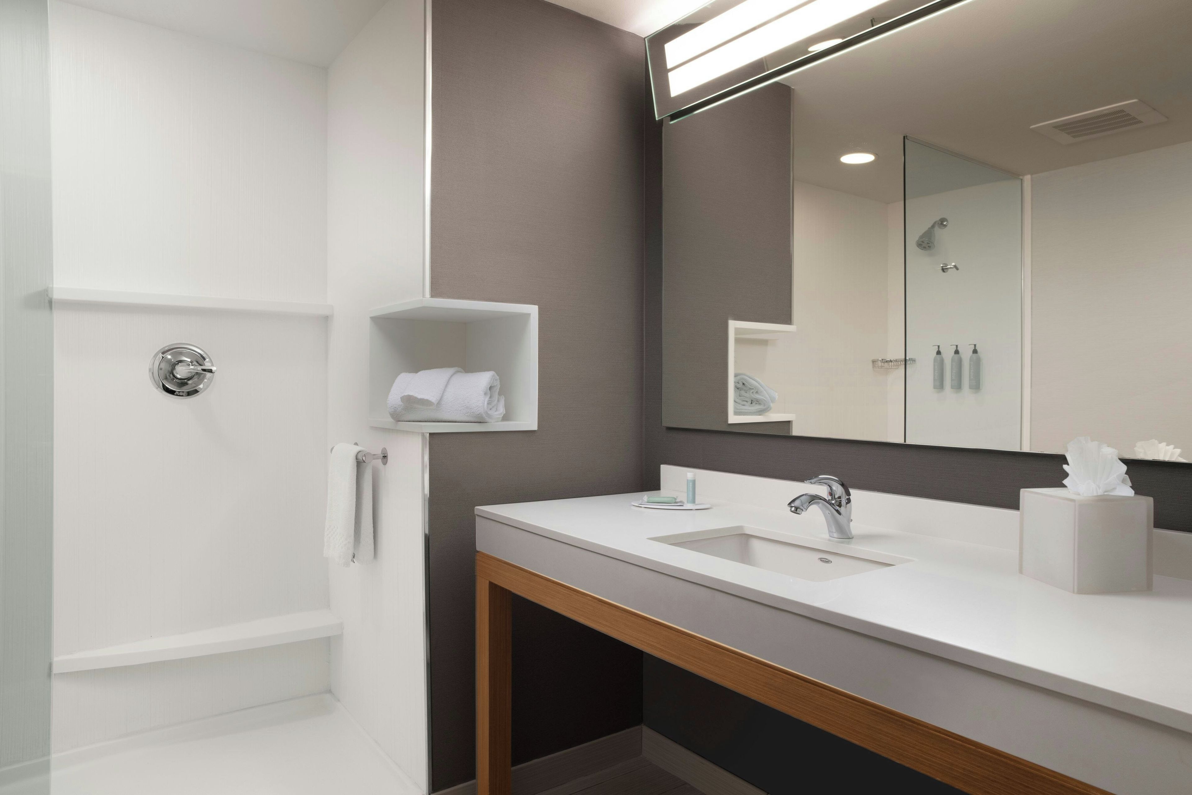 Un baño moderno con bañera, lavamanos y espejo.
