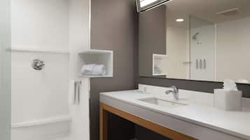 Un baño moderno con bañera, lavamanos y espejo.