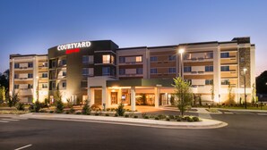 Un hôtel Courtyard by Marriott au design moderne, avec plusieurs étages et une entrée bien éclairée.