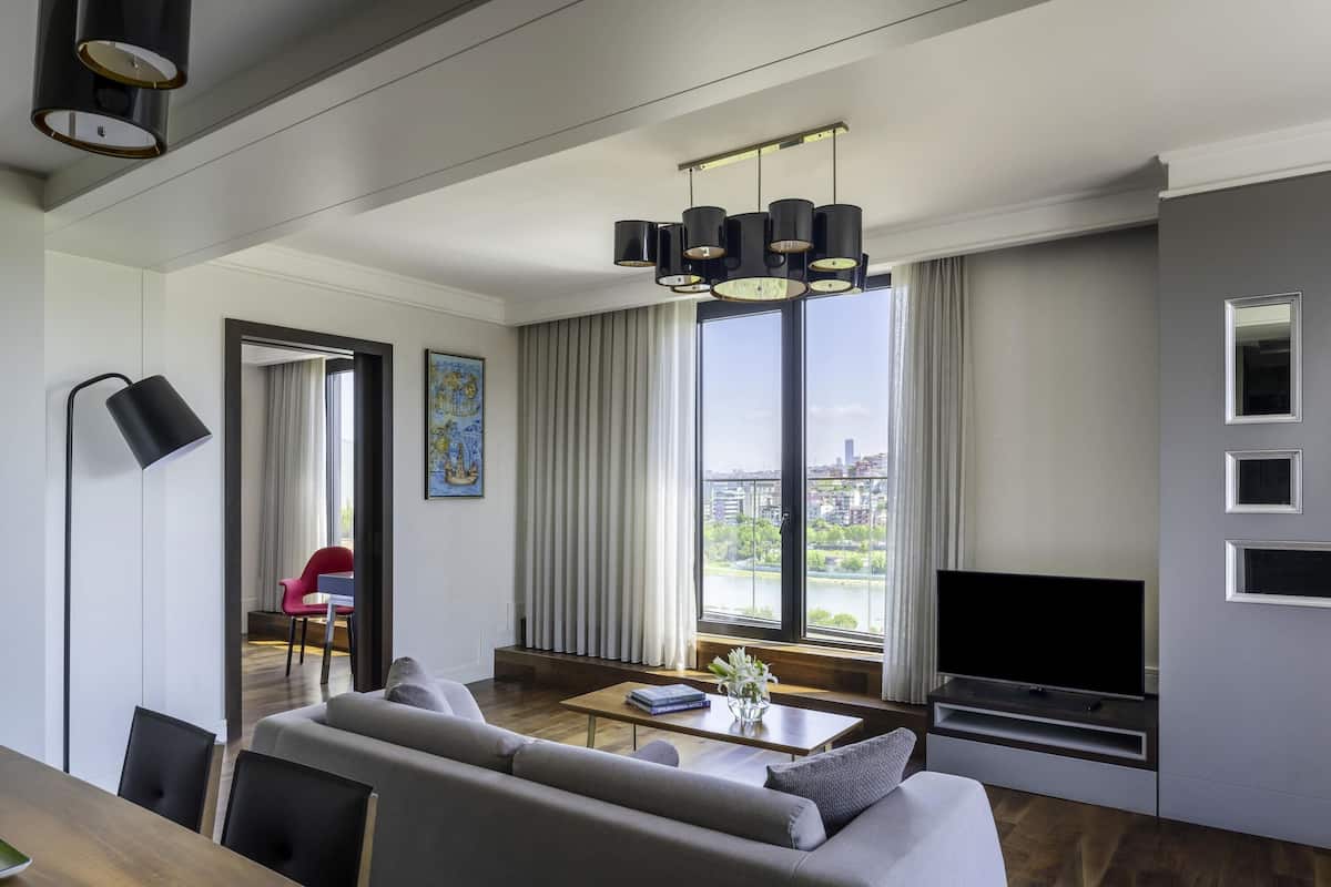 A modern living room with a sofa, TV, and dining area.