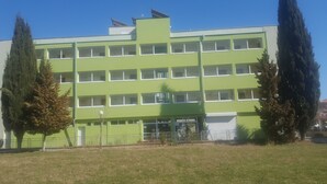 A multi-story building with a flat roof, large windows, and a green facade. - Family Hotel Romantic (Sunny Beach)