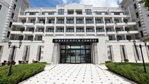A multi-story hotel with a symmetrical facade, large glass entrance, and a central sign reading "WEICHBOCK CASTLE". - White Rock Castle Suite Hotel & Wellness Club (Balchik)