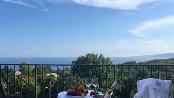 Enjoy a tranquil dining experience with a view of the lush landscape and sea.