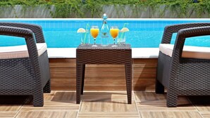 A poolside setting with wicker chairs and a table with drinks. - White Rock Castle Suite Hotel & Wellness Club (Balchik)