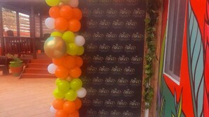 Een gebouwtrappe met een kleurrijke ballonboog en een deur met een patroon.