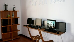 Un espacio de trabajo con un escritorio, múltiples monitores, un teclado, un ratón y una silla de madera.