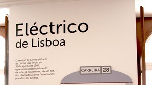 Señal de tranvía con el texto 'Elétrico de Lisboa' y 'Tranvía de Lisboa', junto a una ilustración de tranvía.