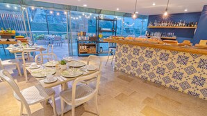 A restaurant with outdoor seating, a buffet bar, and a view of the city. - GHL San Lazaro Art Hotel (Cartagena)