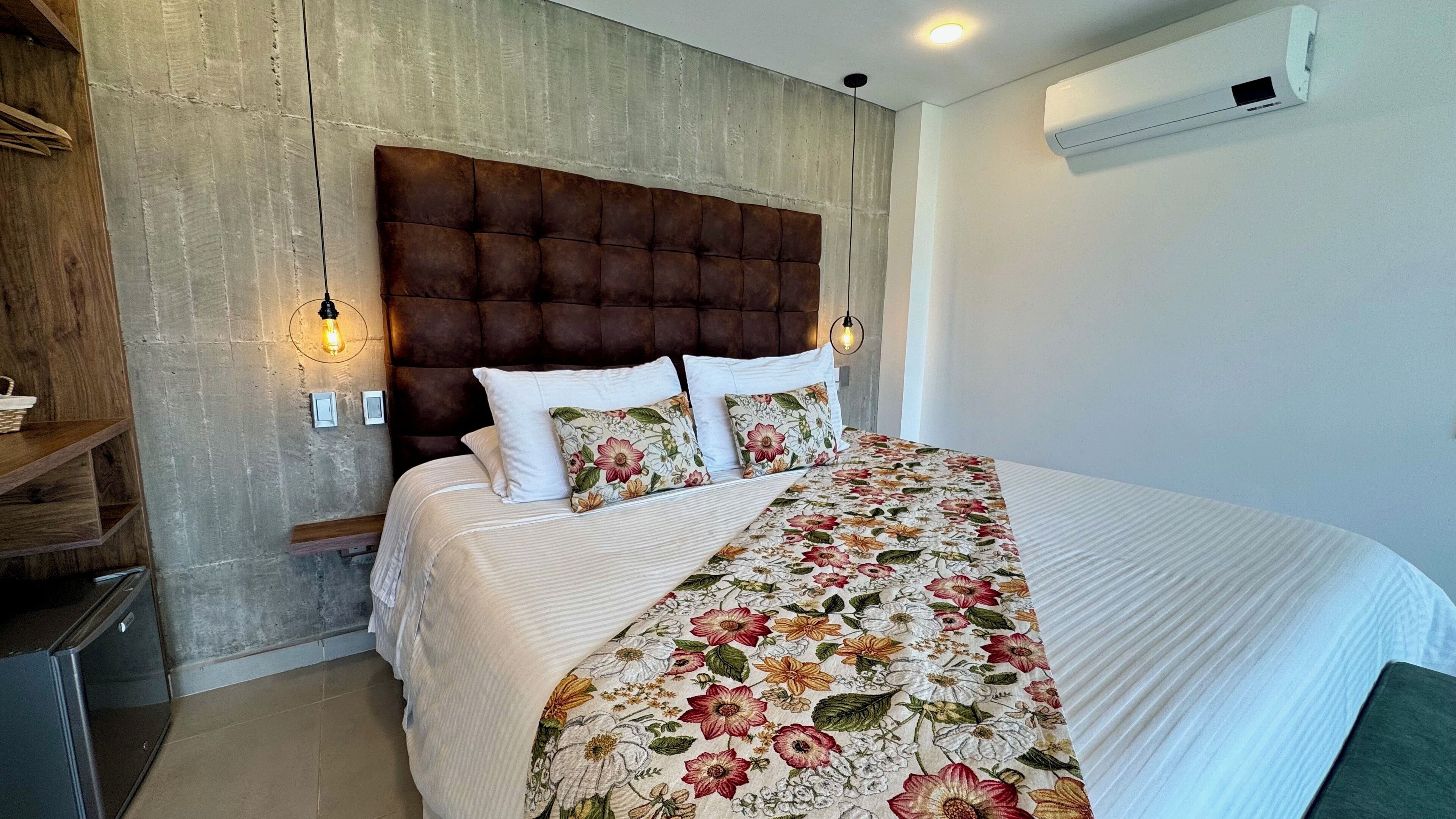 A bedroom with a large bed, a wooden headboard, and a floral bedspread.