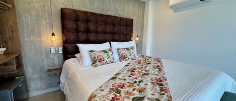 A bedroom with a large bed, a wooden headboard, and a floral bedspread.