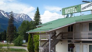 A motel with a green roof and a sign that reads "FIREWEED MILE".