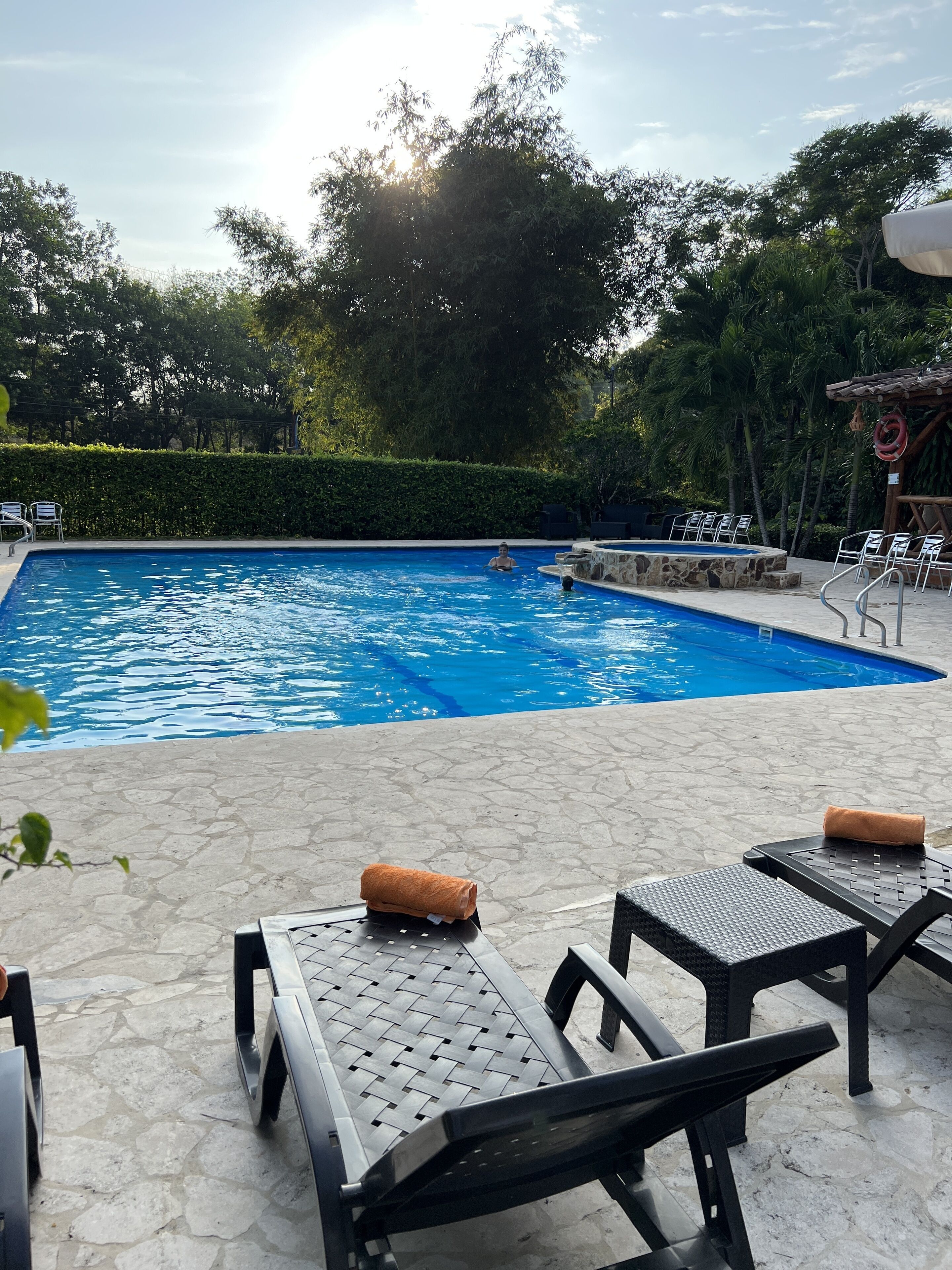 A swimming pool with lounge chairs and a stone-tiled deck.