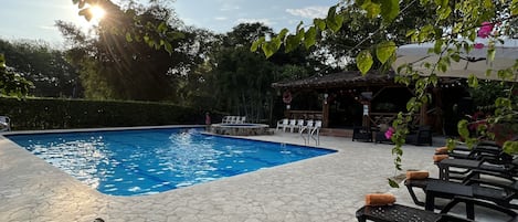 Alberca al aire libre y camastros