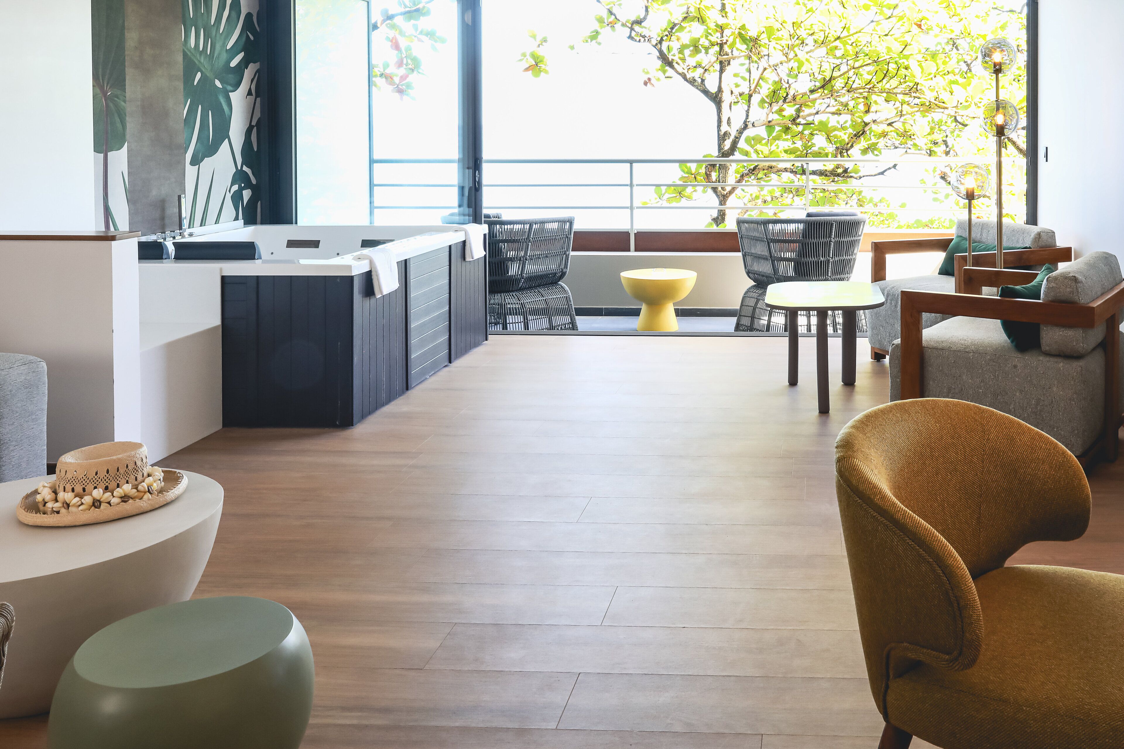 A modern interior with a kitchen area, seating with a view, and a wooden floor.