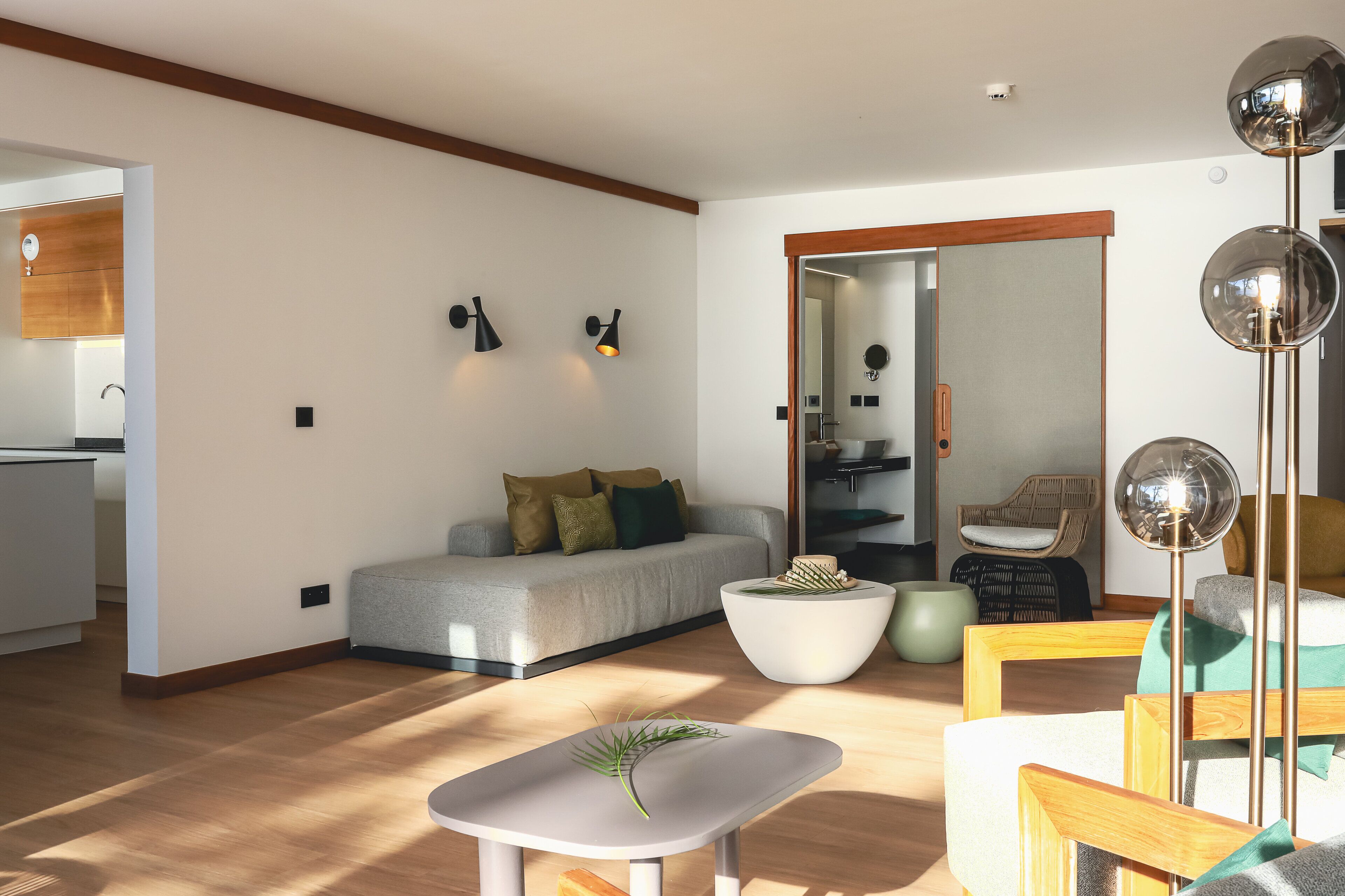 A modern living room with a sofa, coffee table, and a dining area.