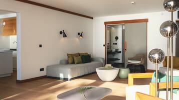 A modern living room with a sofa, coffee table, and a dining area.