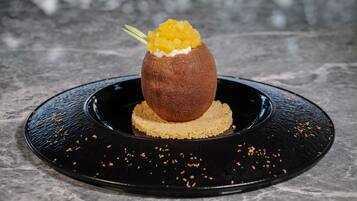 A dessert on a black plate with a textured base.