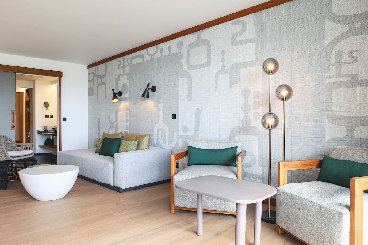 Ein modernes Wohnzimmer mit einer Couch, einem Sessel und einem runden Couchtisch.