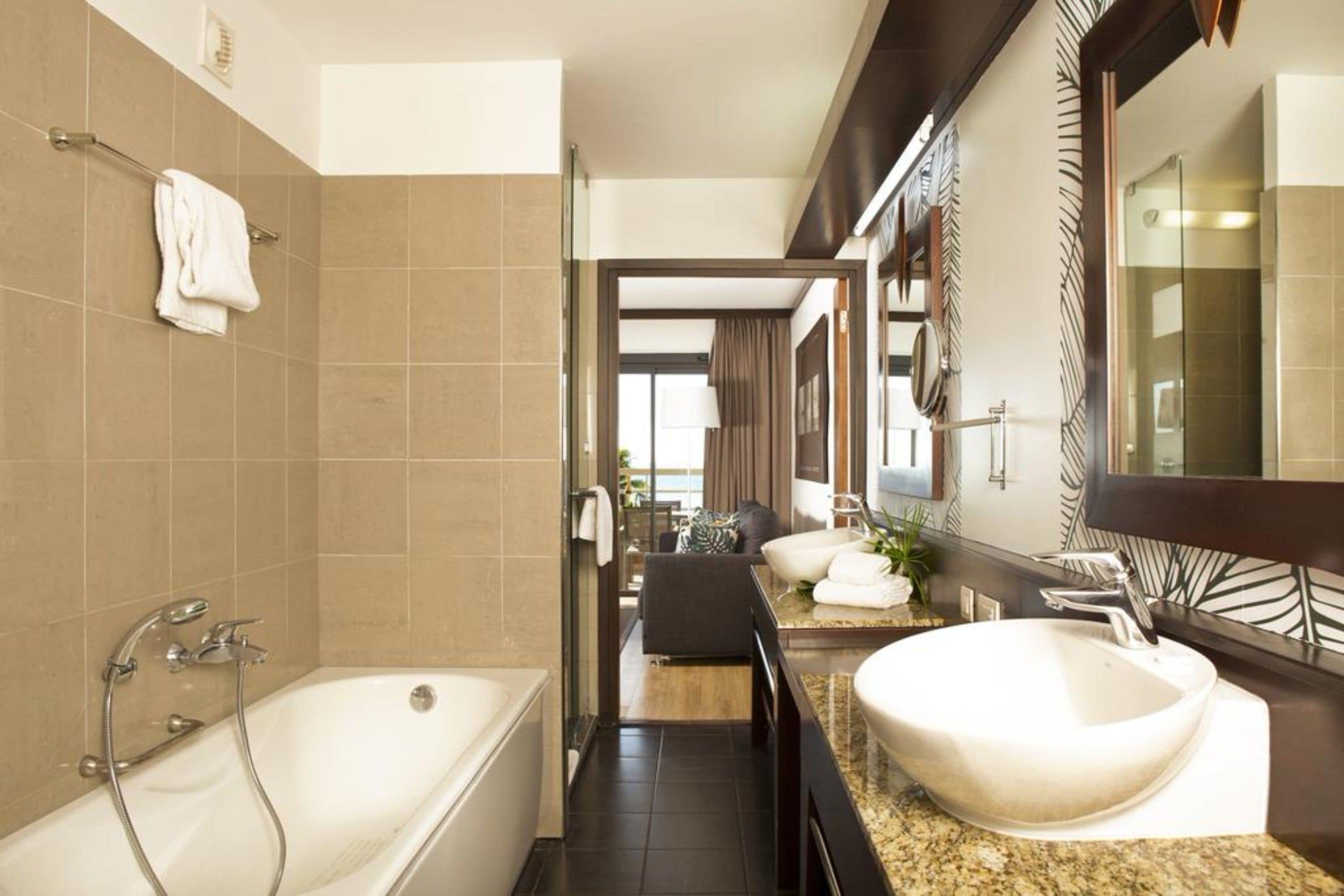 Un baño moderno con bañera, un lavamanos grande y un espejo.