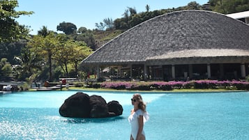 Alberca al aire libre, sombrillas en la alberca y camastros