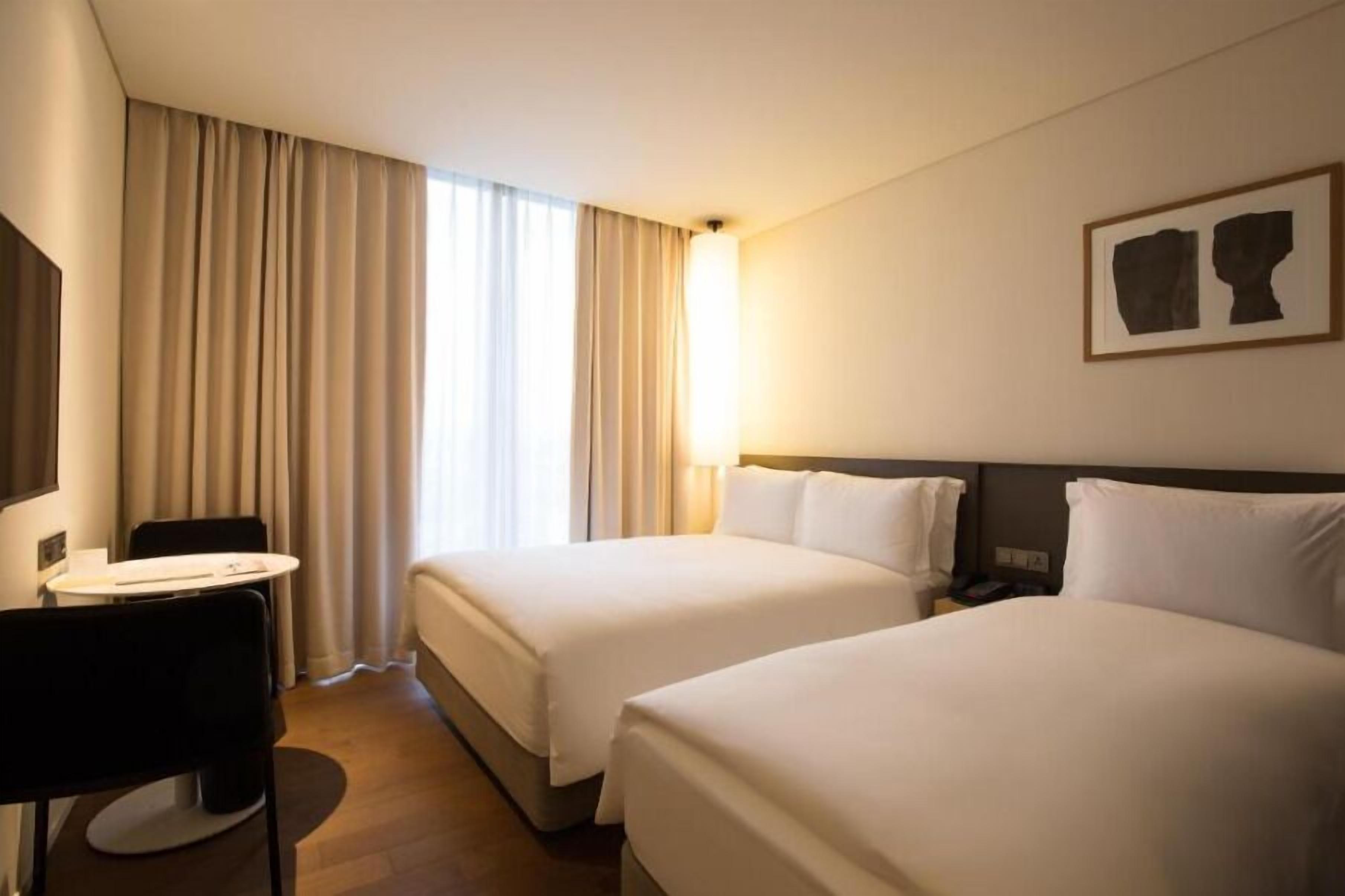 Una habitación de hotel con dos camas, un escritorio y una silla.