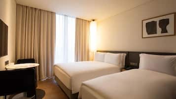 Una habitación de hotel con dos camas, un escritorio y una silla.