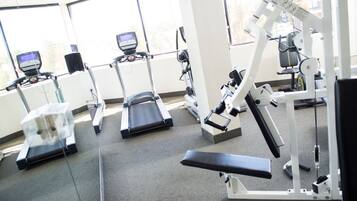 Ein Fitnessstudio mit Laufbändern, Crosstrainern und Gewichten.