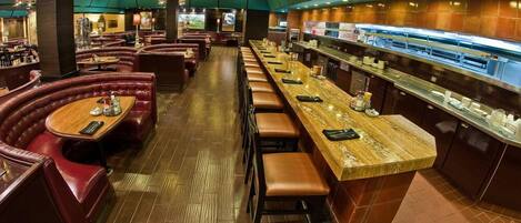 A restaurant with booth seating and a long counter with stools.