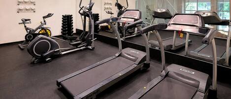 A gym with treadmills, stationary bikes, and weight machines.